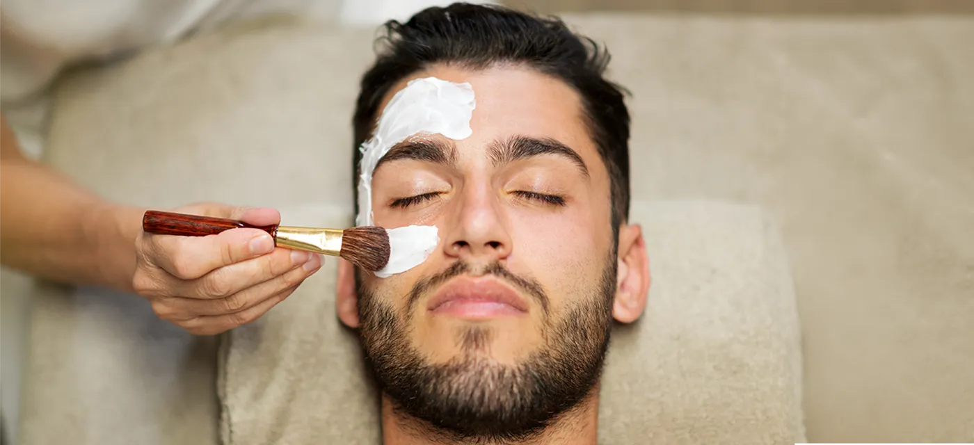 A guest receiving a facial masque applied with a brush